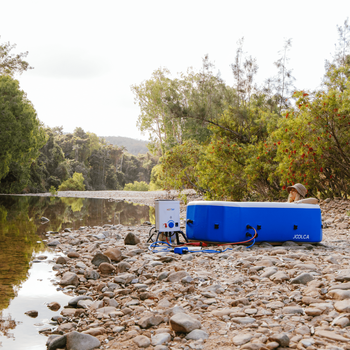 Joolca HOTTUB set up on a rocky riverbank with a HOTTAP heater