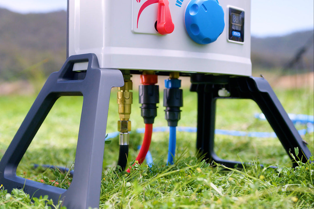 HOTTAP V2 standing on grass on its lightweight grey feet, with gas and water hoses connected underneath