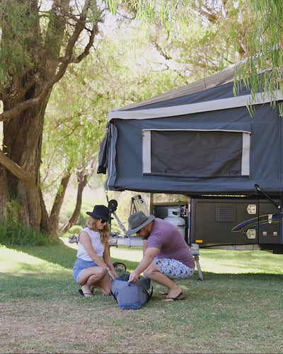 Family setting up the Joolca Ensuite Double shower tent outdoors on grass