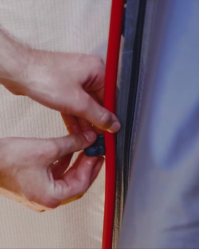 Point-of-view shot of a hand holding the Joolca shower head against a blue sky